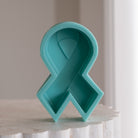An aesthetic Breast Cancer Ribbon Candle Mould silicone candle mould from MYKA Candles and Moulds, perfect for soap, resin, and cake mould art.