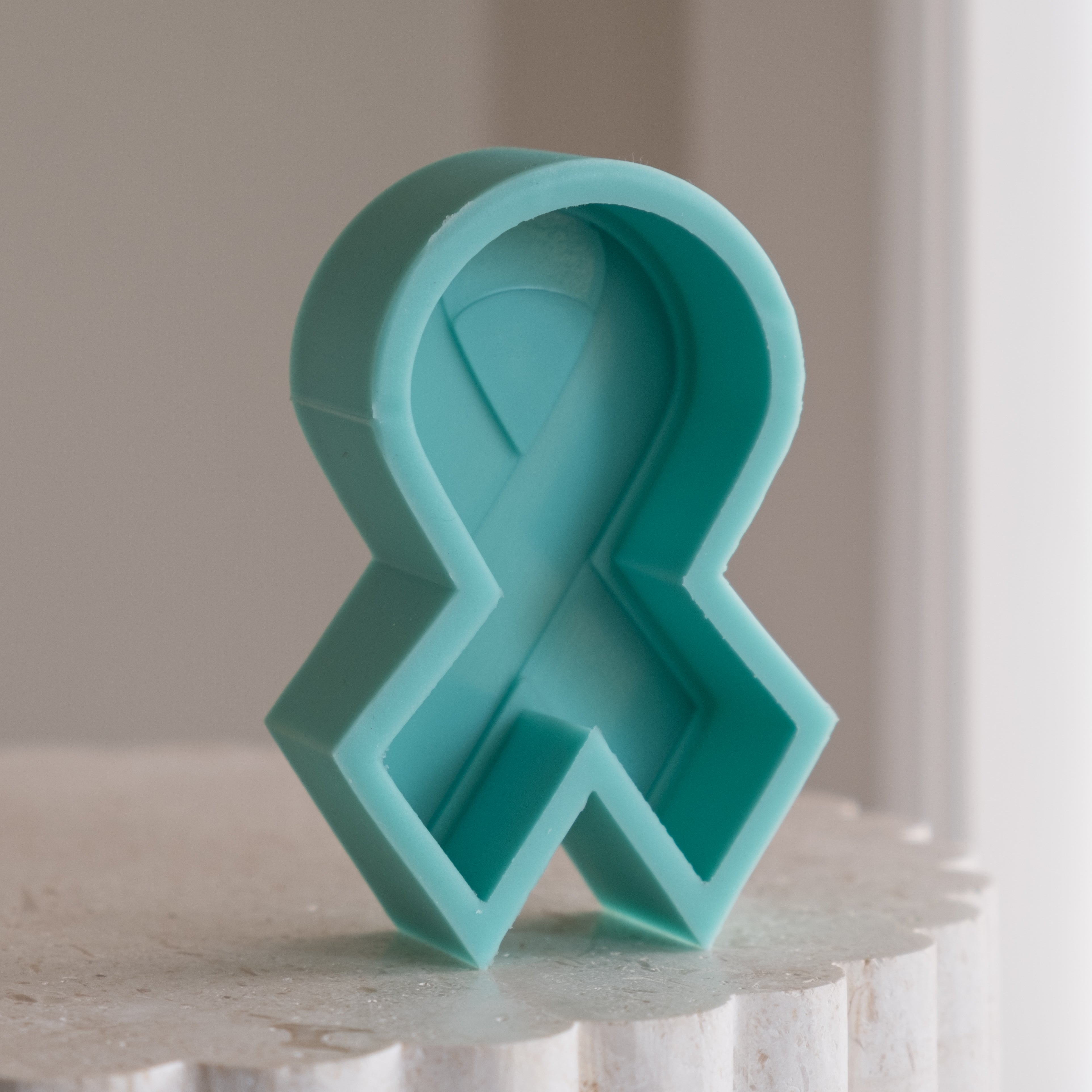 A high-performance Breast Cancer Ribbon Candle Mould silicone candle mold from MYKA Candles and Moulds for resin art and professional baking mould use.